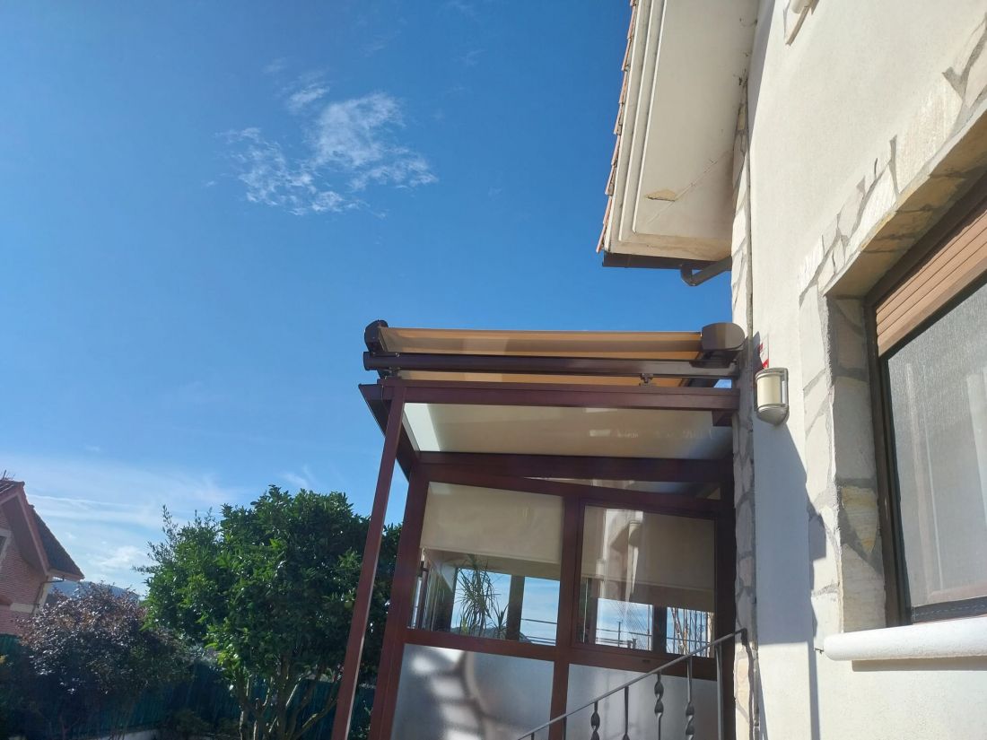 Toldo de color crema en techo de  terraza y ventanas