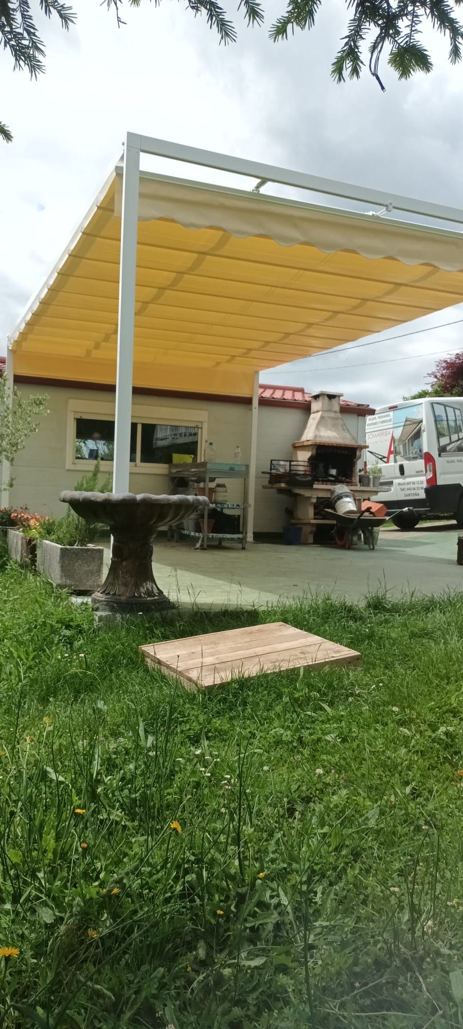 Toldo amarillo cerrado en terraza pérgola